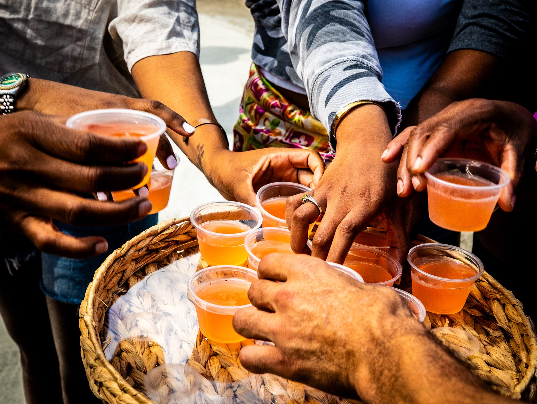 Hands reaching for drink samples at a tasting event