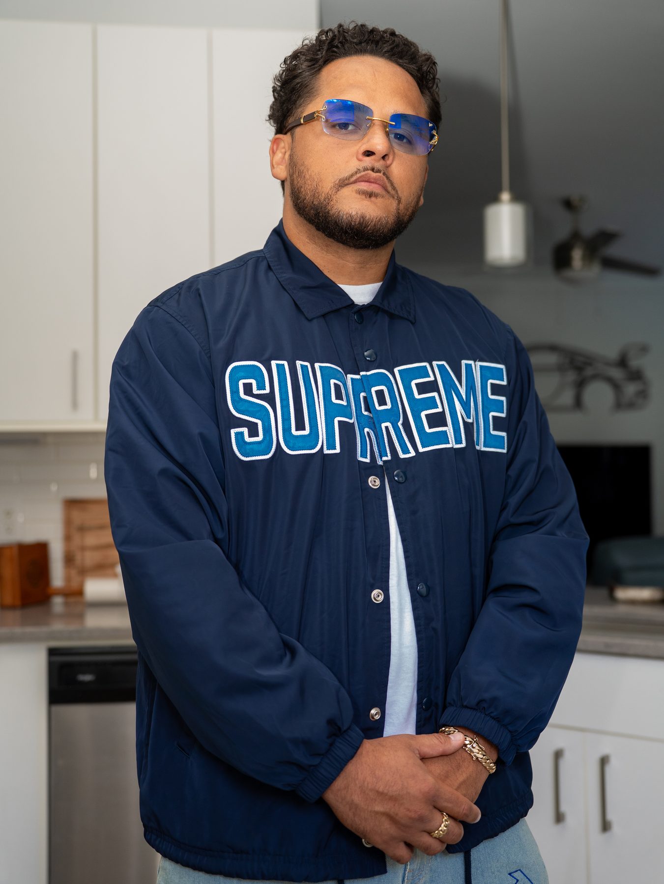 Portrait of a man in a navy Supreme jacket for an in-house brand shoot